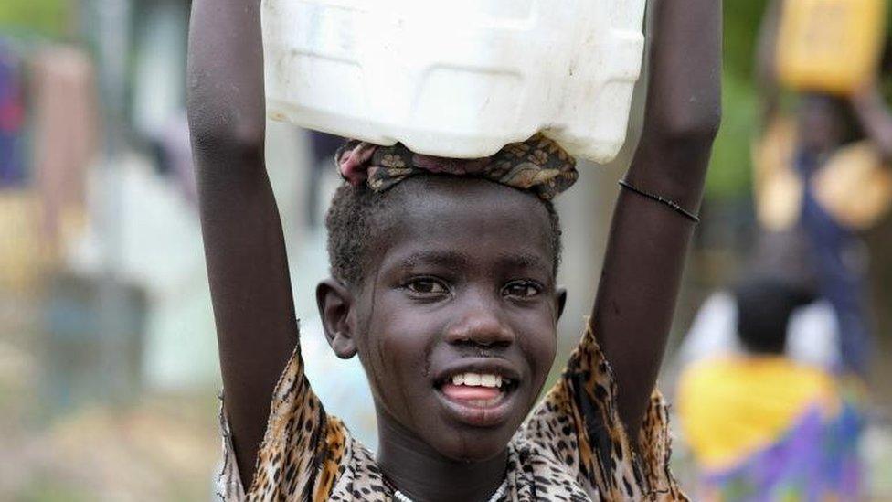 Sandy Chuol, 10, heads home with the jerrycan of clean water that she collected at a UNICEF-supported water point, in war-ravaged Malakal Town, South Sudan