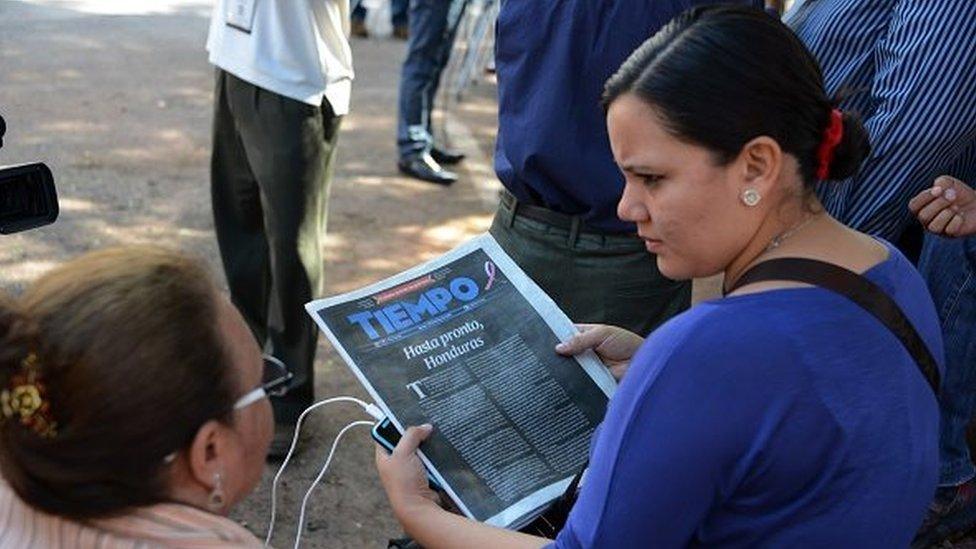 A woman holds the 27 October, 2015 edition of Tiempo newspaper