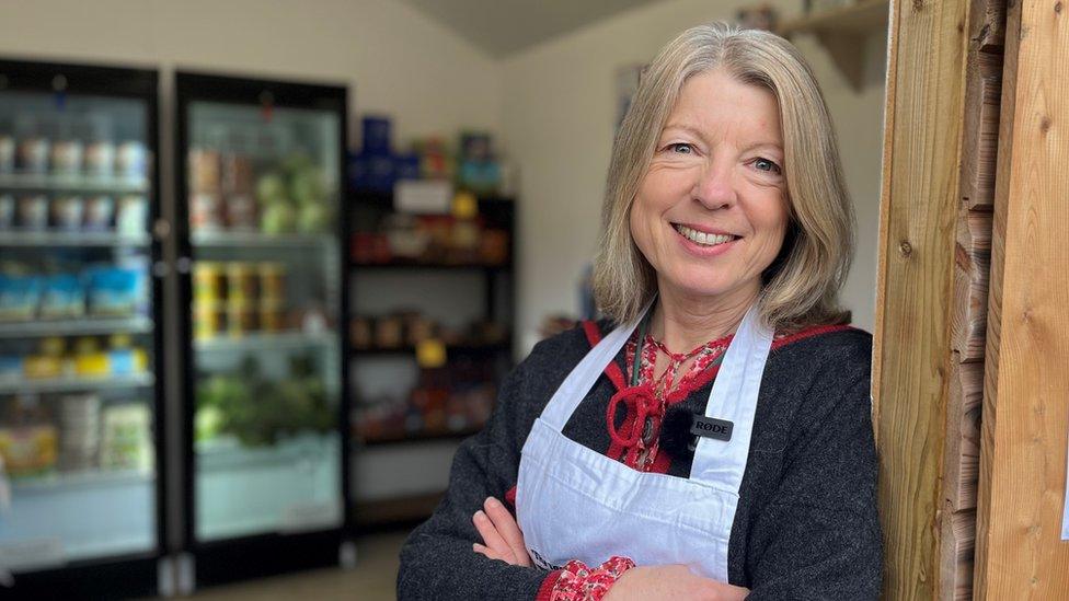 a woman in the doorway of a food pantry