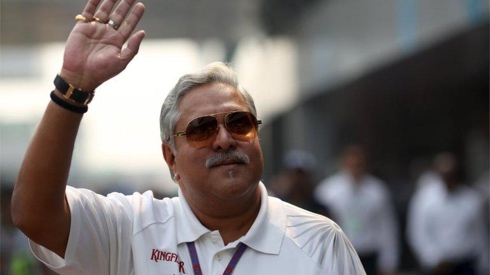 Force India team principal Vijay Mallya waves in the paddock during the third practice session of the Indian F1 Grand Prix at the Buddh International Circuit in Greater Noida