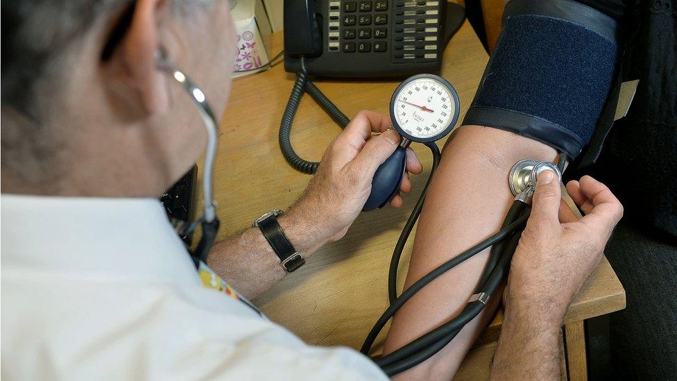 Doctor checking patient's blood pressure