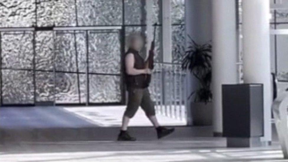 The alleged gunman wandering around inside Field's Shopping Centre