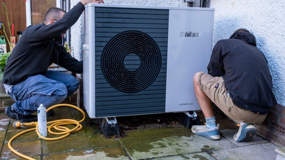 people installing heat pump