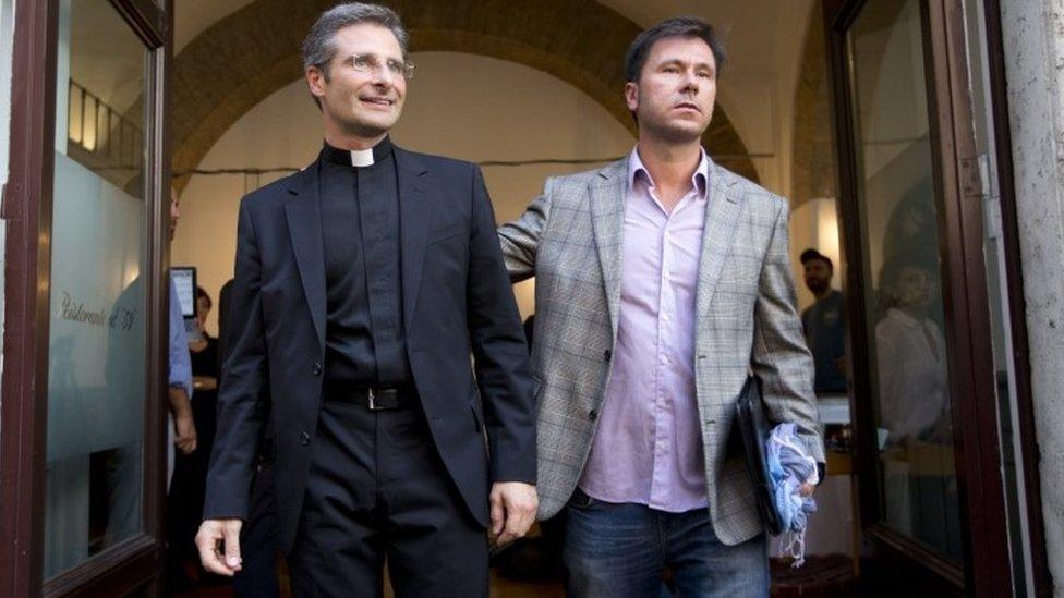 Monsignor Krzysztof Charamsa (left) and his partner Eduard leave a restaurant after a press conference in downtown Rome (03 October 2015)