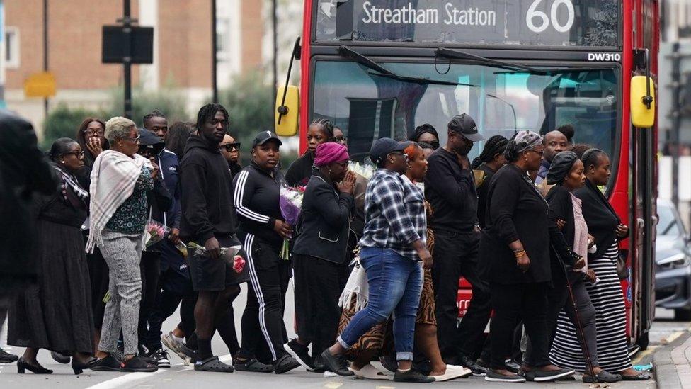 Family members and friends gathering in a group of more than 20 people on Wellesley Road.