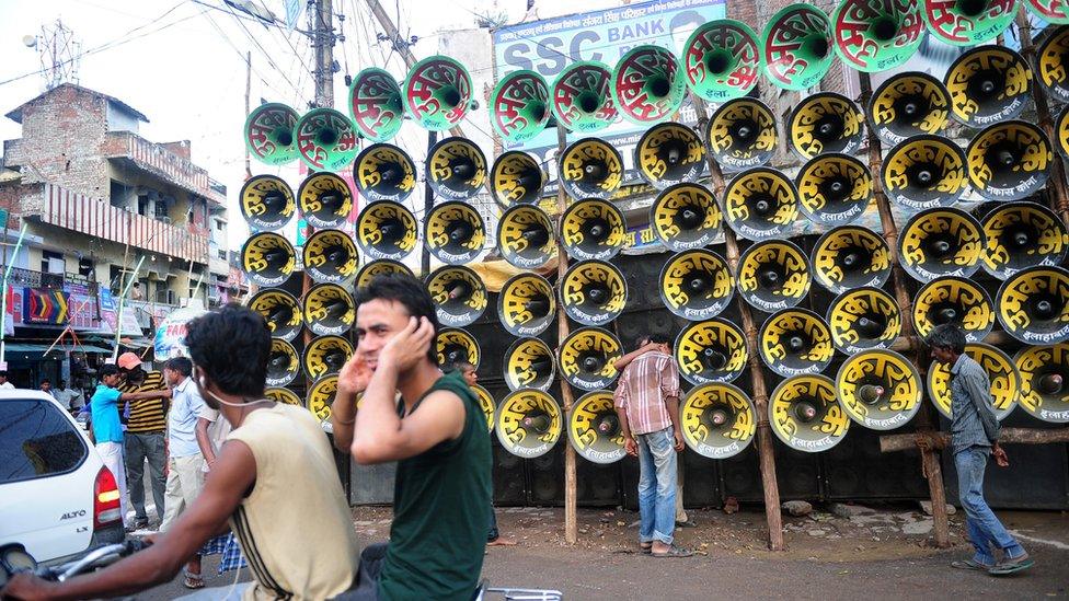 An Indian man protects his ears with his hands during a loudspeaker competition ahead of the Dussehra Hindu festival in Allahabad on September 20, 2015