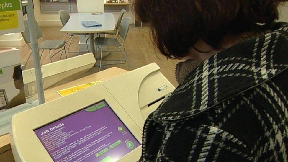 woman looks at jobpoint terminal inside a jobcentre