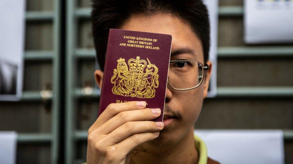 A petitioner is seen holding up a BNO passport outside the British Consulate in Hong Kong on August 21, 2019