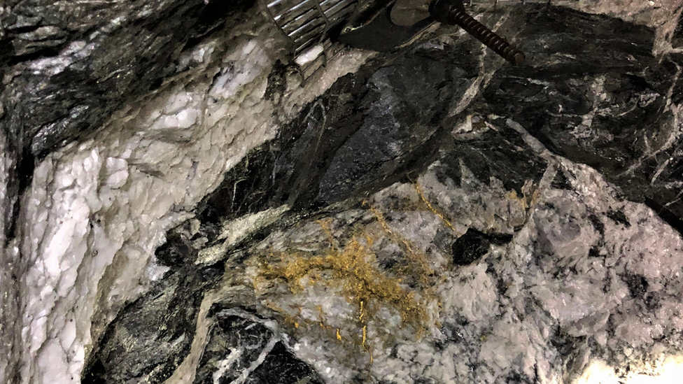 Gold seen in the rock face of the mine