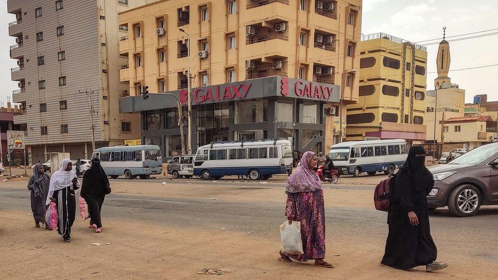 Women walk along the street in south Khartoum