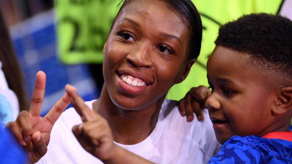 Grace Geyoro holds a child at the end of the UEFA Women's Euro 2022 Group D football match between Iceland and France.