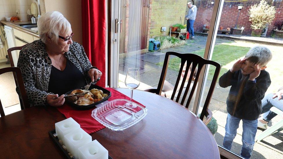 Zac looks through the window at Vera Barnett after delivering a carvery meal from the Sneyd Arms on Mother"s Day in Keele, Newcastle-under-Lyme as the spread of the coronavirus disease continues.