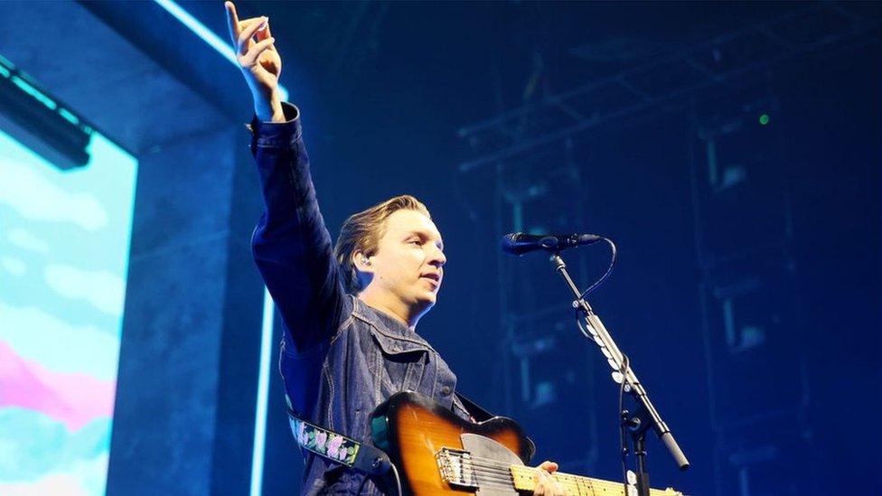 George Ezra singer on stage with his guitar