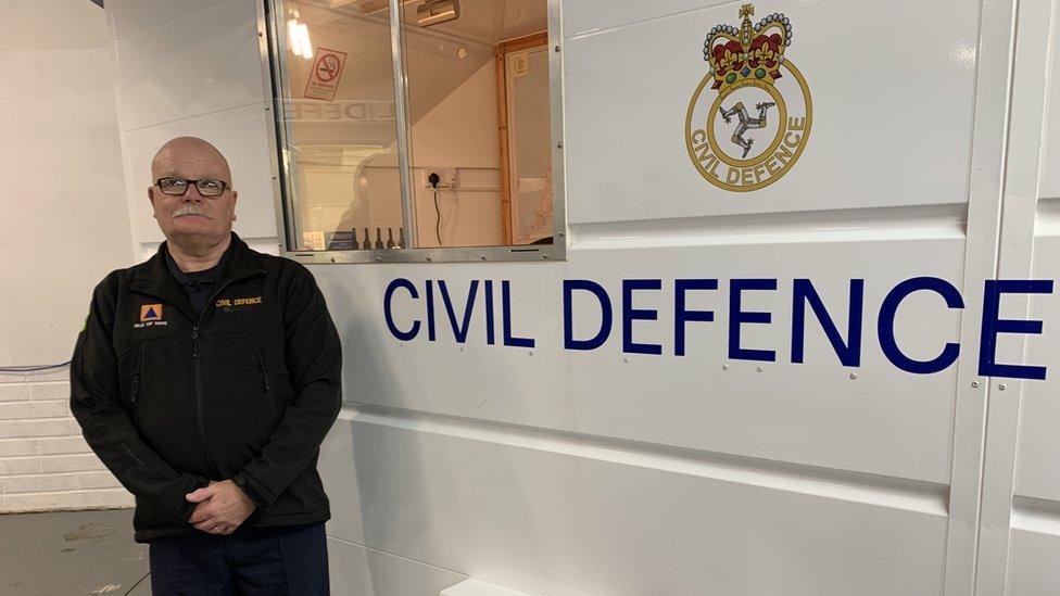 Russell Smith standing next to a Civil Defence trailer