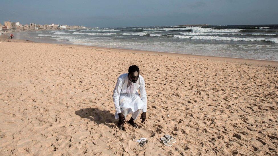 A member of the Layene community prays on the beach in front of the Yoff Layene Mosque, during the Islamic festivity of Korite in Dakar, Senegal, on May 24, 2020,