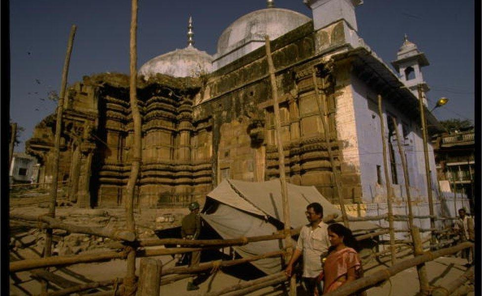 Police in security precaution at disputed Hindu/Muslim site, w. ruins of original Vishwanath Temple (fore) & Gyanvapi Mosque (built over temple in 1669