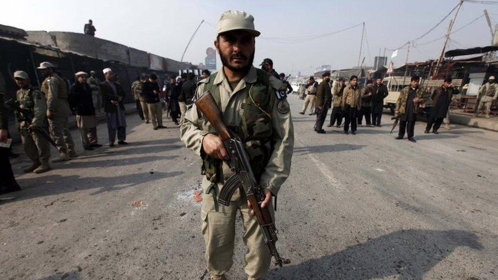 A member of the Pakistani security services at the site of a bomb blast targeting a paramilitary check post on the outskirts of Peshawar (19 January 2016)