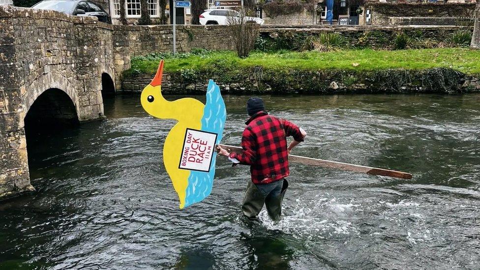 A man holding a rubber duck sign