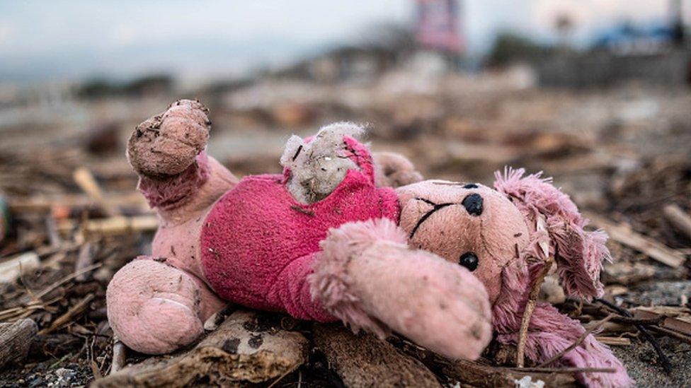 Childrens toys in the rubble of houses