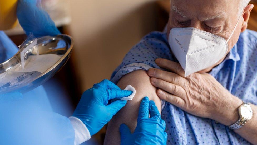 An elderly man receives a Covid-19 vaccination