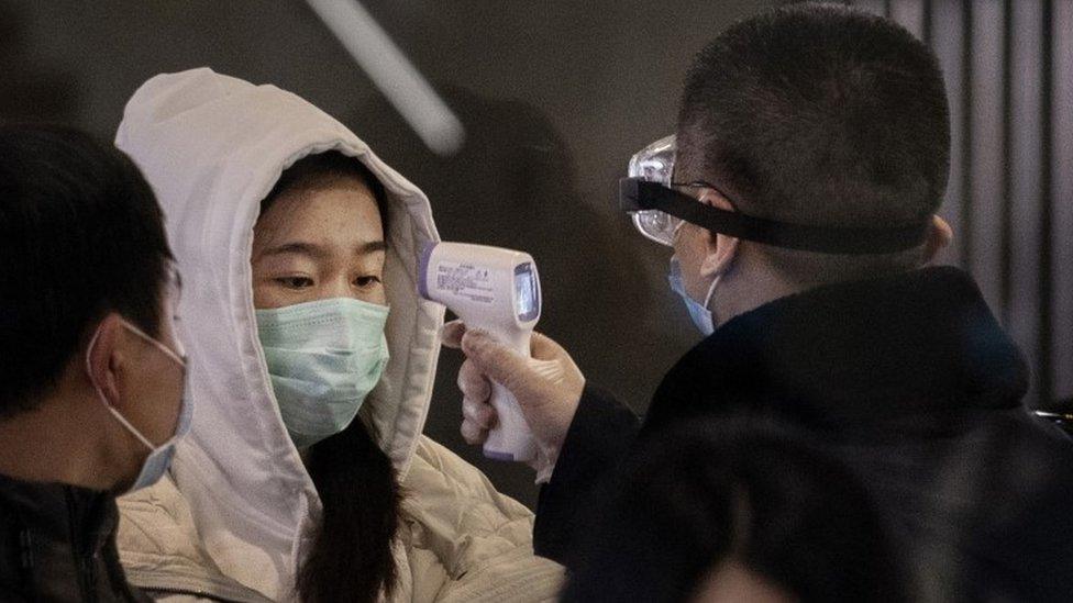 Train passenger being checked for fever