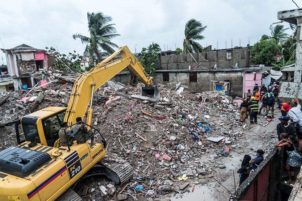 A bulldozer clears the rubble of a collapsed building in Brefet, a neighborhood of Les Cayes, Haiti, on 17 August 2021