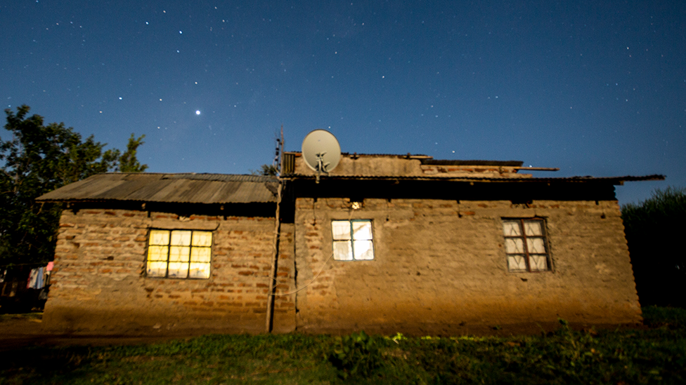 House with satellite dish at night