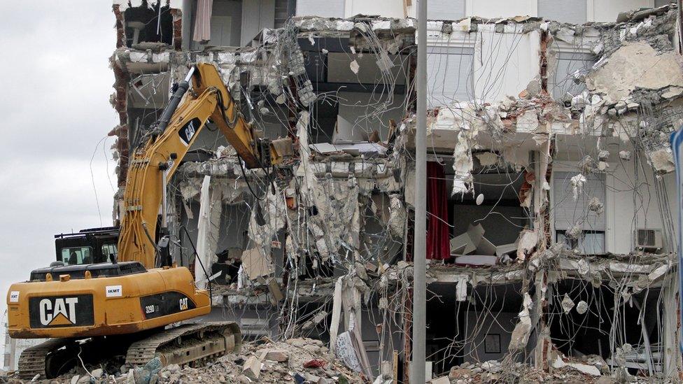 An excavator works at a damaged building in Durres