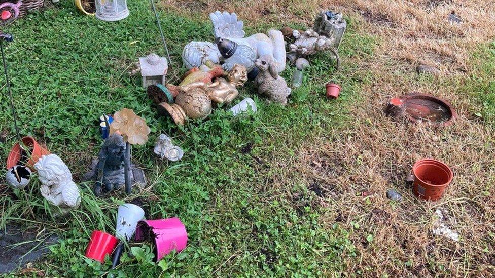 Trinkets strewn across the grass in the memorial garden