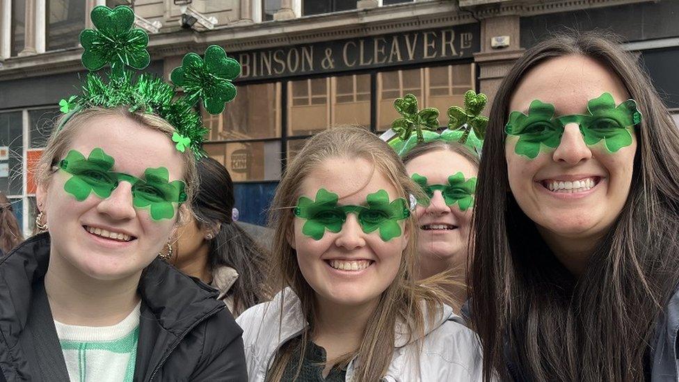 Three young women with green novelty glasses