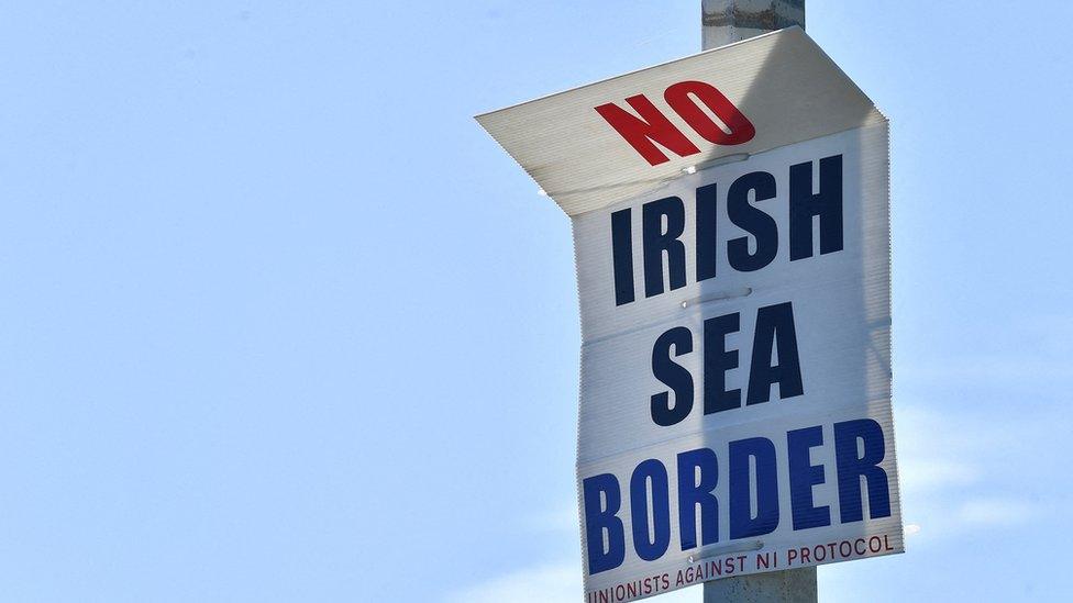 A poster reading "No Irish Sea border" is seen at the port in Larne in June 2022