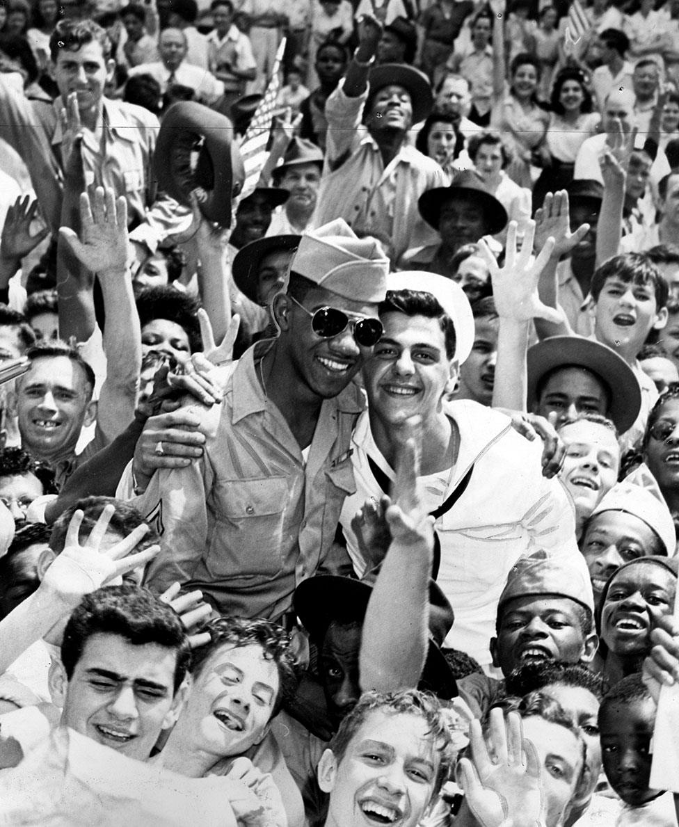 Soldiers in a crowd of cheering people