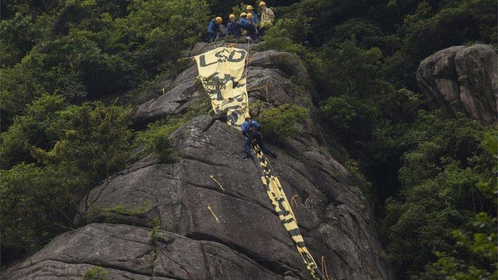 Giant democracy banner on Hong Kong hill ahead of China state leader visit