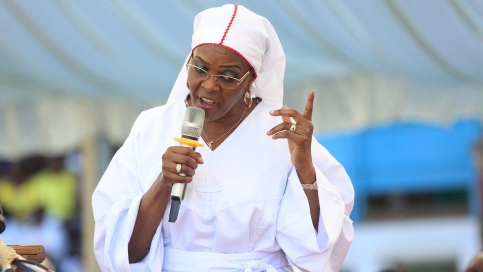 Grace Mugabe, with a microphone speaking, dressed all in white in November image