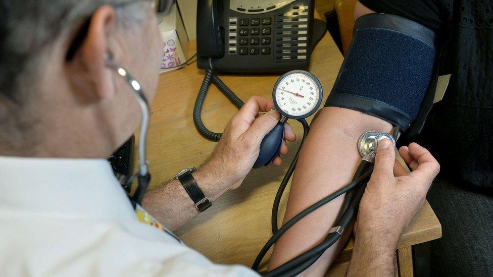 A GP checking a patient's blood pressure