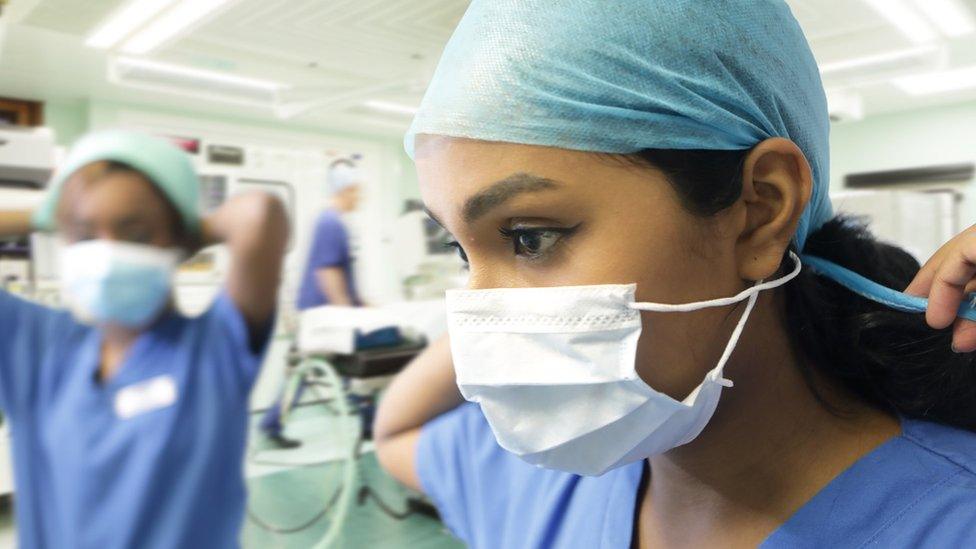 Hospital staff putting on PPE