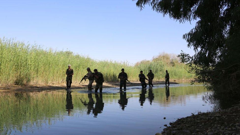 Syrian pro-government fighters are seen in the Euphrates river outside the eastern city of Deir al-Zour in 2017