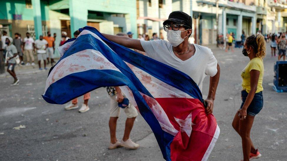 A man waves a Cuban flag during a demonstration against the government of Cuban President Miguel Diaz-Canel in Havana