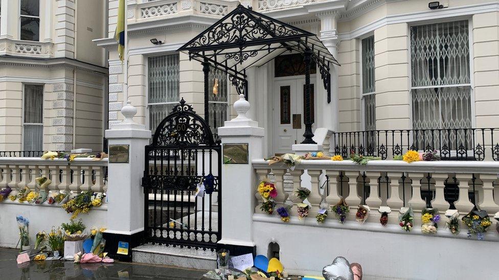 Flowers and balloons surround the gates of the Ukrainian embassy in London