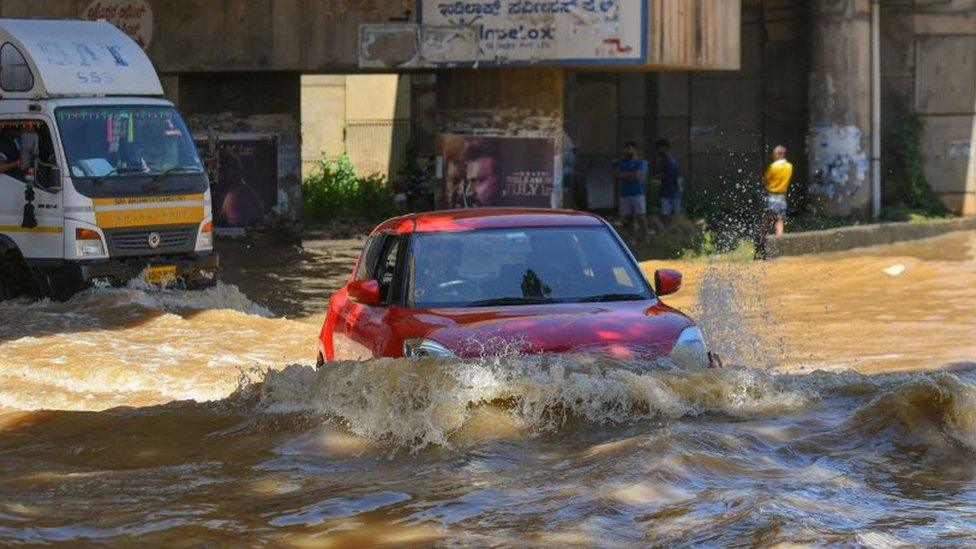 Vehicles wade through a street after heavy monsoon rains in Bangalore on September 5, 2022.