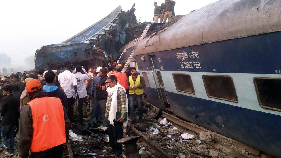 Indian rescue workers search for survivors in the wreckage of a train that derailed near Pukhrayan in Kanpur district