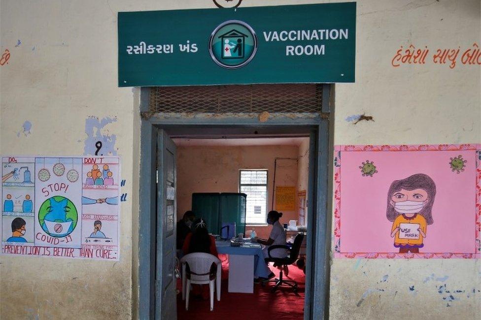 Healthcare workers sit inside a classroom of a school, which has been converted into a temporary vaccination centre, during a nationwide trial run of COVID-19 vaccine delivery systems, on the outskirts of Ahmedabad, India.