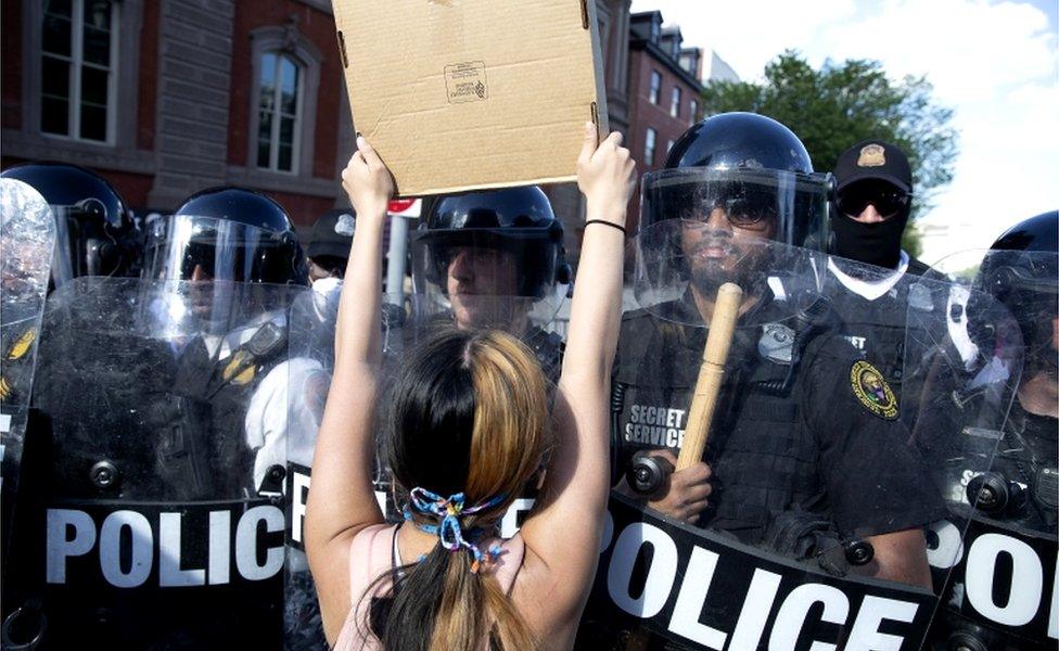 A protester squares up to riot police in Lafayette Square Park in Washington, DC, 30 May 2020