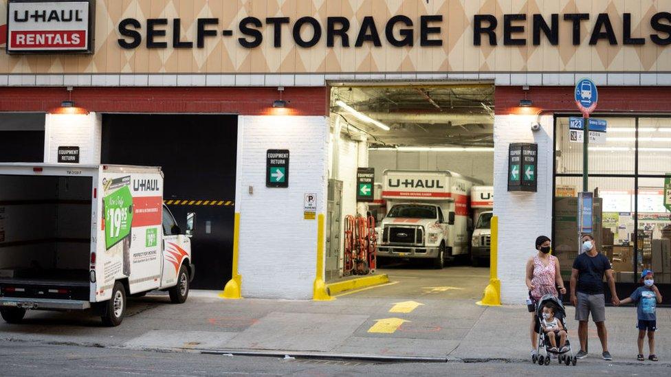 People wearing masks are seen standing outside a U-Haul rental depot on August 01, 2020 in New York City.