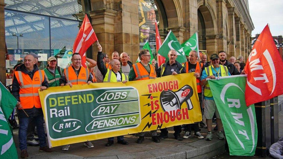 Members of the Rail, Maritime and Transport union (RMT) on a picket line outside Liverpool Lime Street station