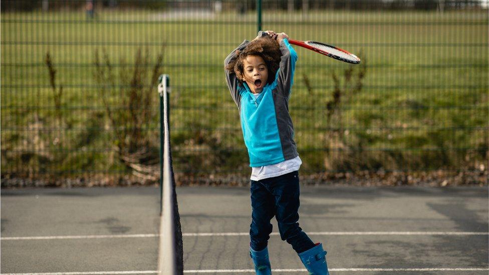 Child playing tennis