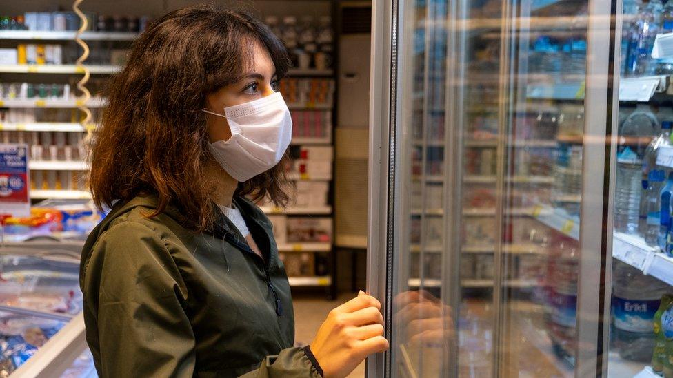 Woman wearing a mask in a shop