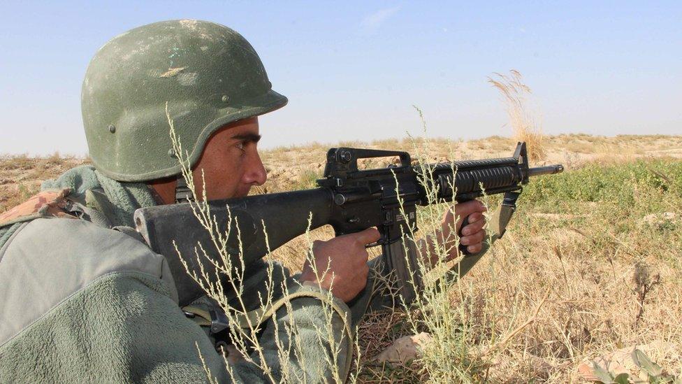 An Afghan security official with a rifle takes up a position during an operation against Taliban militants in Lashkar Gah, Afghanistan, 18 December 2016.