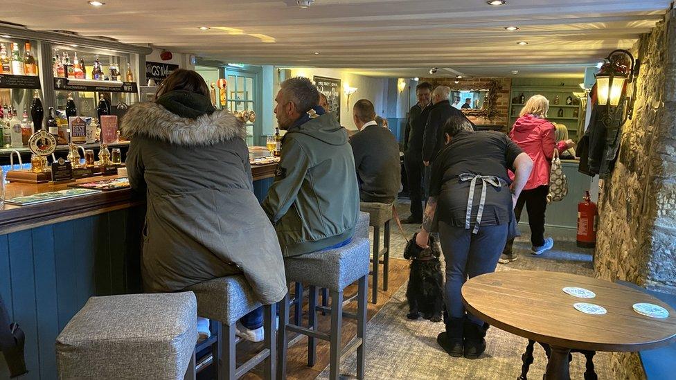 The inside of the Coach Inn Lesbury with people gathered around the bar