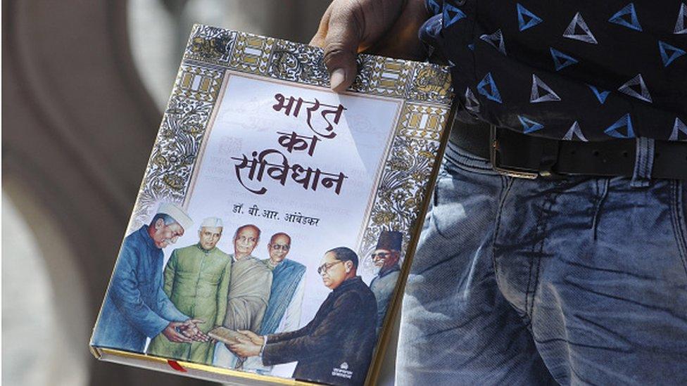 : A man holds a book of the Indian constitution on the occasion of the 128th birth anniversary of Dalit icon BR Ambedkar at Rashtriya Dalit Prerna Sthal, sector 95 on April 14, 2019 in Noida, India.